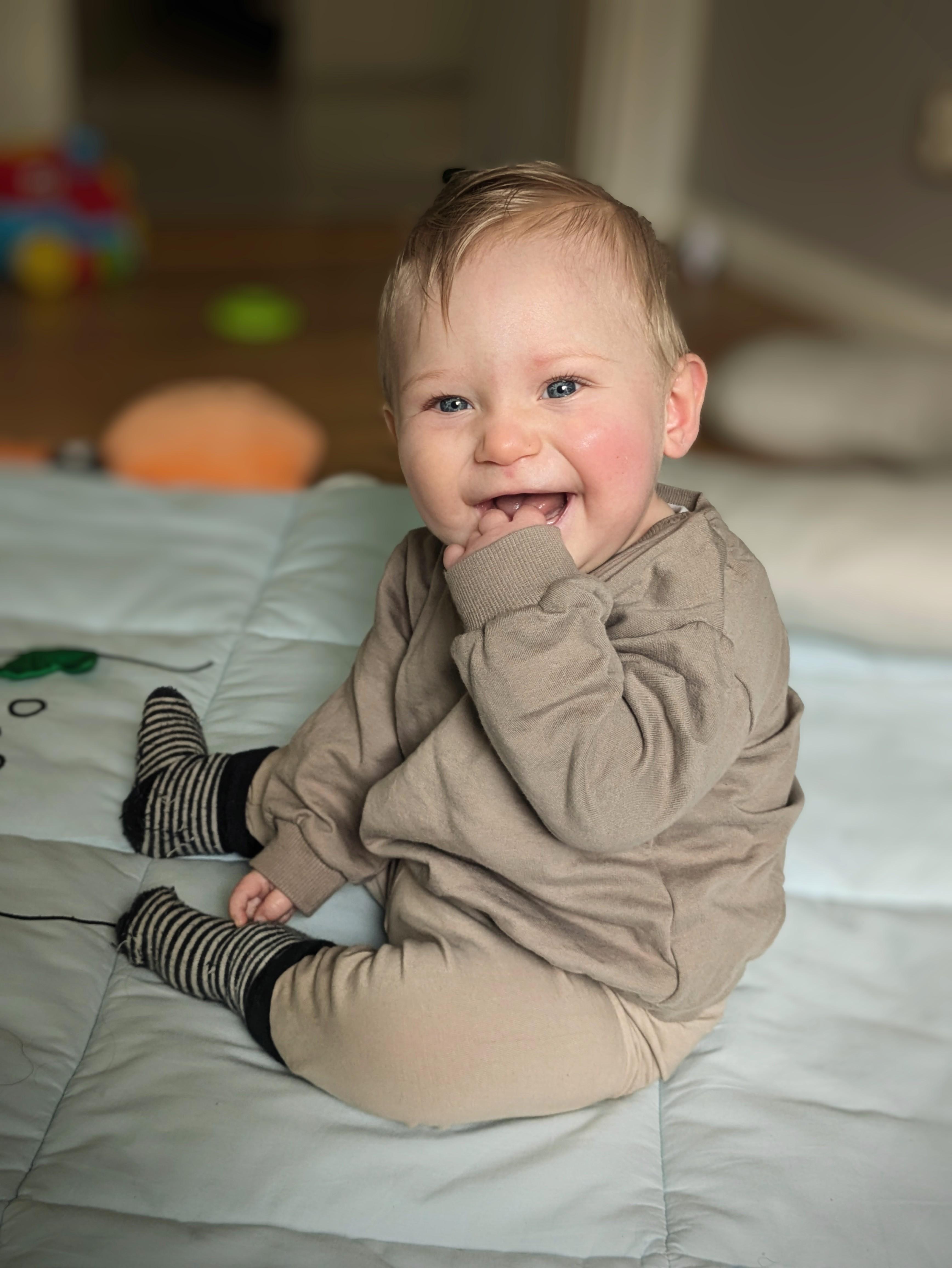Nico snart ett år väldigt glad sittandes på golvet